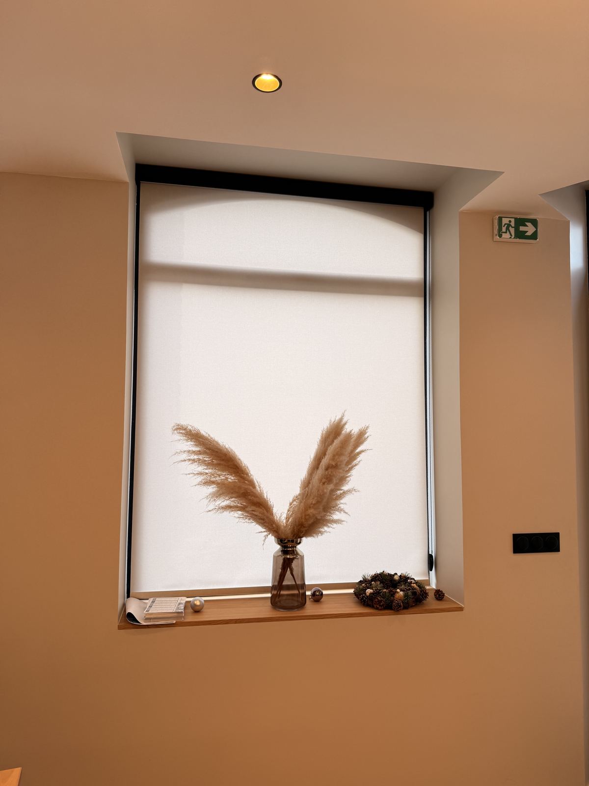 Store enrouleur tissu clair filtrant la lumière dans un bureau contemporain